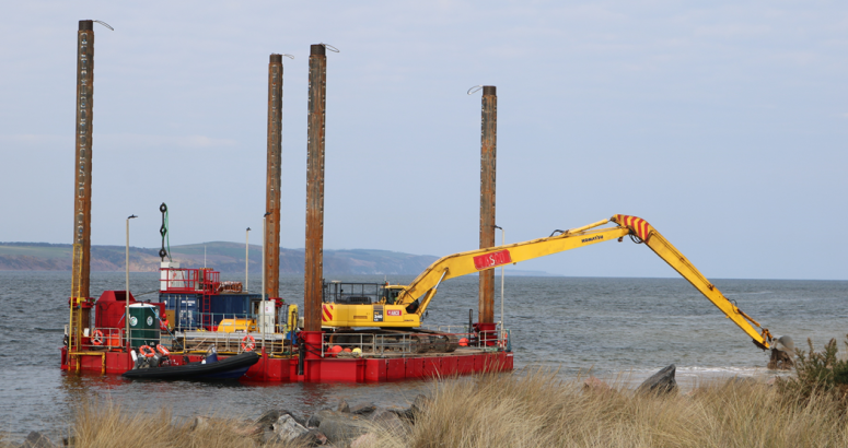An excavator operating from a jack-up barge during the extension of the outfall, east of Fort George, into deeper water in the Moray Firth