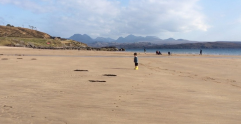 People on Sand Beach, near Gairloch, with Torridon mountains in the distance