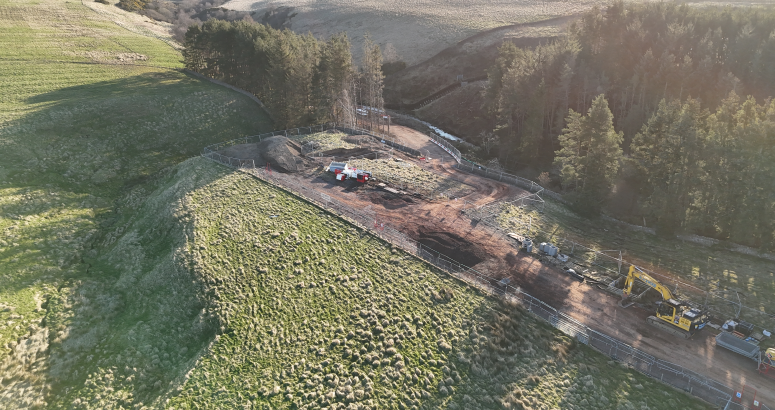 Gladhouse Reservoir Site Compound Aerial view of a construction site surrounded by wooded areas with machinery and vehicles at work