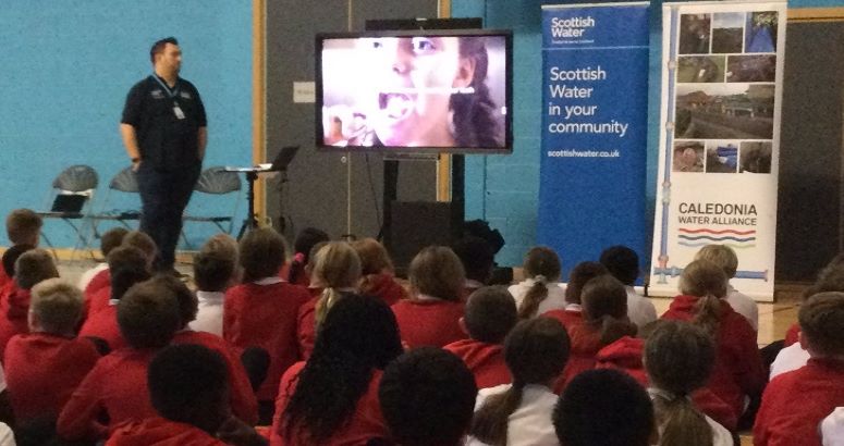 Employee from Scottish Water's Partner CWA, delivering presentation to group of school pupils