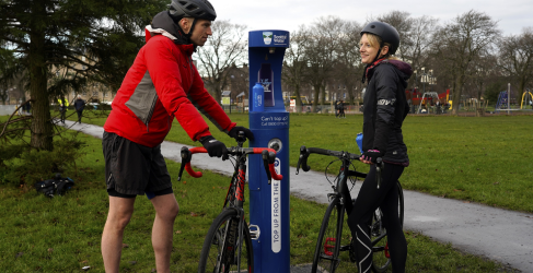 Two people with bikes standing next to Top Up Tap