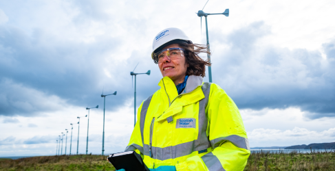 Female Scottish Water worker standing in front of wind turbine