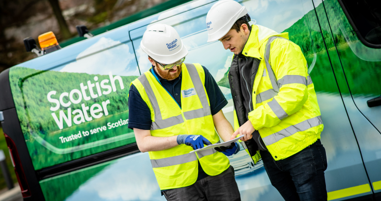 Two graduates pictured with Scottish Water van behind