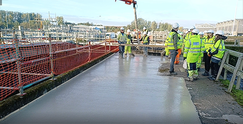 Construction workers on site with newly poured concrete