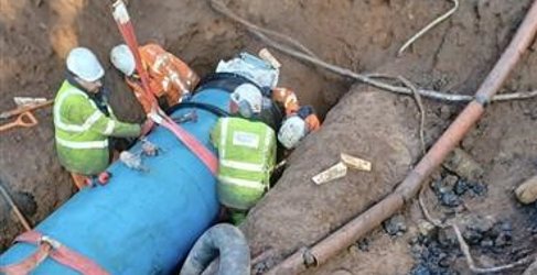 Engineers install the new section of water main Auchenhowie Milngavie Burst
