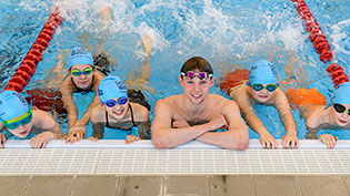 Children and teacher in a line in a swimming pool