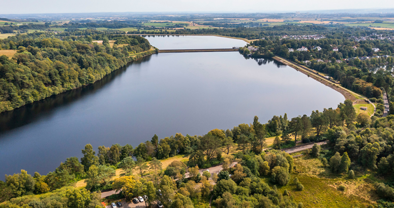 A large reservoir with tress round it