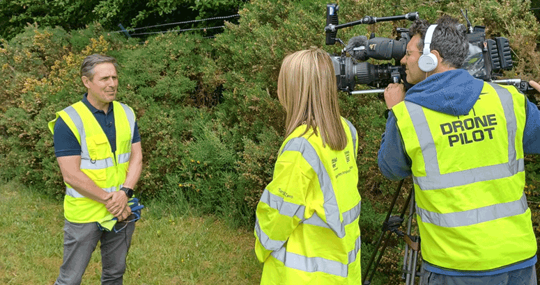 People in  hi vis filming an interview