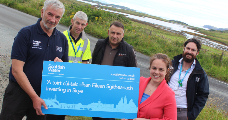 Kate Forbes MSP at Dunvegan with members of the team involved with delivering the current investment in Skye’s water networks, with the Roag peninsula beyond. They are pictured with a Scottish Water sign reading: ‘A toirt cùl-taic dhan Eilean Sgitheanach / Investing in Skye'
