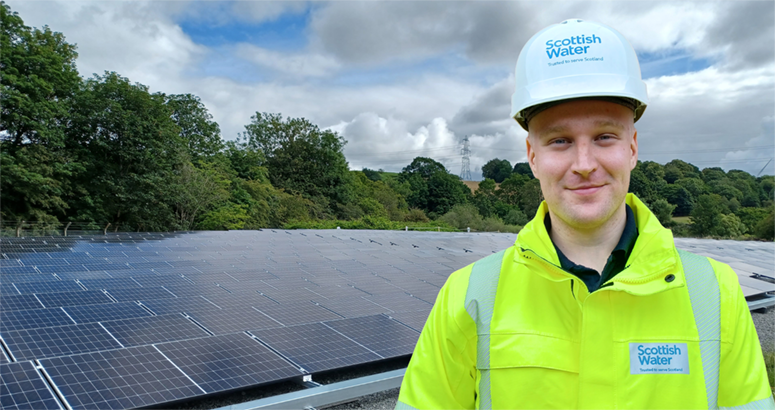 Man in hi viz jacket standing in front of Solar Panels