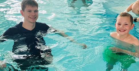 Learn to Swim instructor Nathan McKechnie in pool teaching youngster Jack