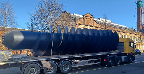 Foul screw arrival at McDonald Road A giant screw pump is shown arriving at McDonald Road on the back of a wagon