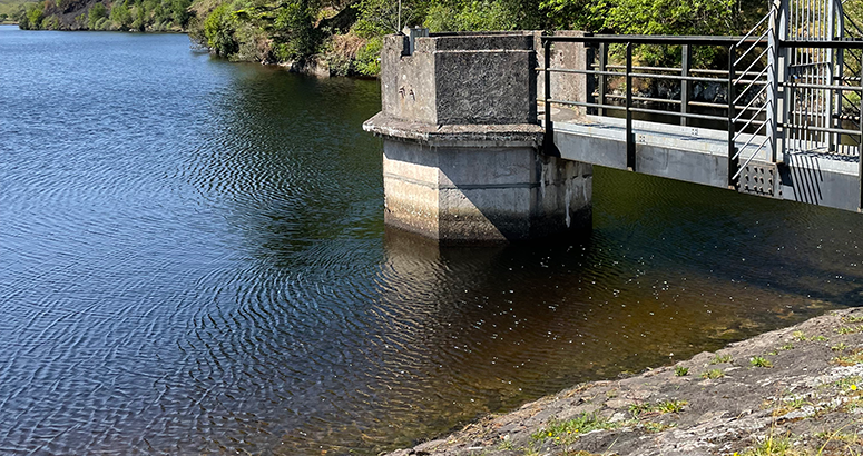 Water Efficency reservoir edge with water tower showing low water line with water tower