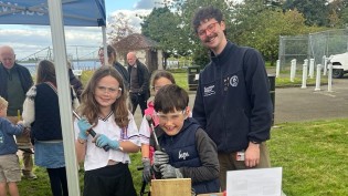 Reservoir Ranger Kieran pictured with children who have just taken part in the bird box building session. One young boy and two young girls holding their tools with Kieran smiling in the background.