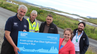 Kate Forbes MSP at Dunvegan with members of the team involved with delivering the current investment in Skye’s water networks, with the Roag peninsula beyond. They are pictured with a Scottish Water sign reading: ‘A toirt cùl-taic dhan Eilean Sgitheanach / Investing in Skye'