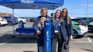 Four Scottish Water Employees smiling beside Top Up Tap Four Scottish Water Employees smiling beside Top Up Tap
