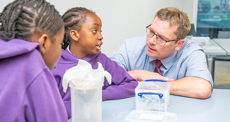 Scottish Water CEO Alex Plant chatting to two children over a water experiment