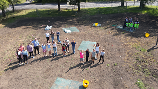 This aerial shot shows school pupils planting on the meadow site