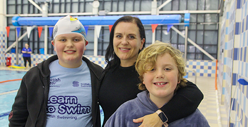 Design a camp competition winner Reuben Norbury wearing his cap, with mum Jane in the centre and little brother Leif