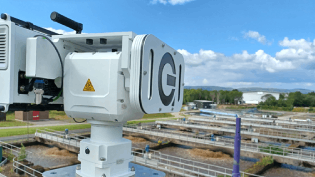 A picture of technology installed at a waste water treatment works. There are blue skies with some cloud, and grass in the background.