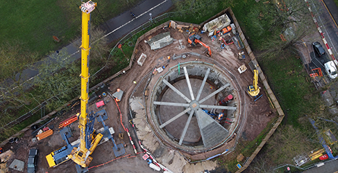 Large circular storm tank under construction, with yellow crane in Marchmont, Edinburgh