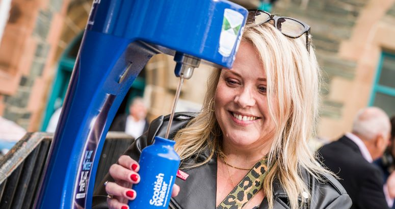 A woman fills up a Scottish Water reusable bottle from the new top up tap