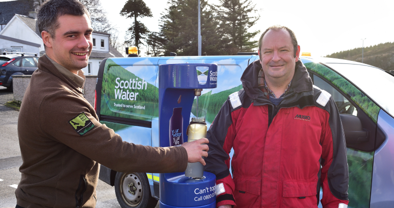Michael Hunter of the North Harris Trust fills his water bottle from the new tap, while councillor Grant Fulton looks on