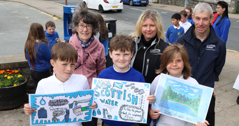 Poster competition winners from P6 at Portree Primary School show off their winning designs at the launch of Portree’s Top up Tap, with (L to R) Margaret Ferguson of Skye Climate Action, Annmarie Campbell of Portree and Braes Community Trust and James MacInnes who leads Scottish Water’s local field response team