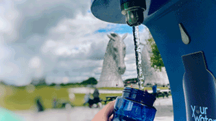 Blue water bottle under water fountain